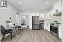 Kitchen featuring white cabinetry, stainless steel appliances, recessed lighting, and wood-finish flooring - 125 Cathcart Street, Hamilton, ON 