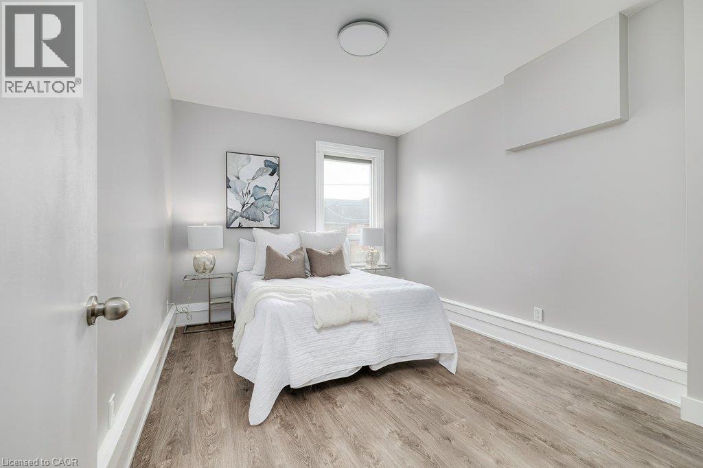 Wood-finish flooring, white trim, and light gray wall paint - 125 Cathcart Street, Hamilton, ON