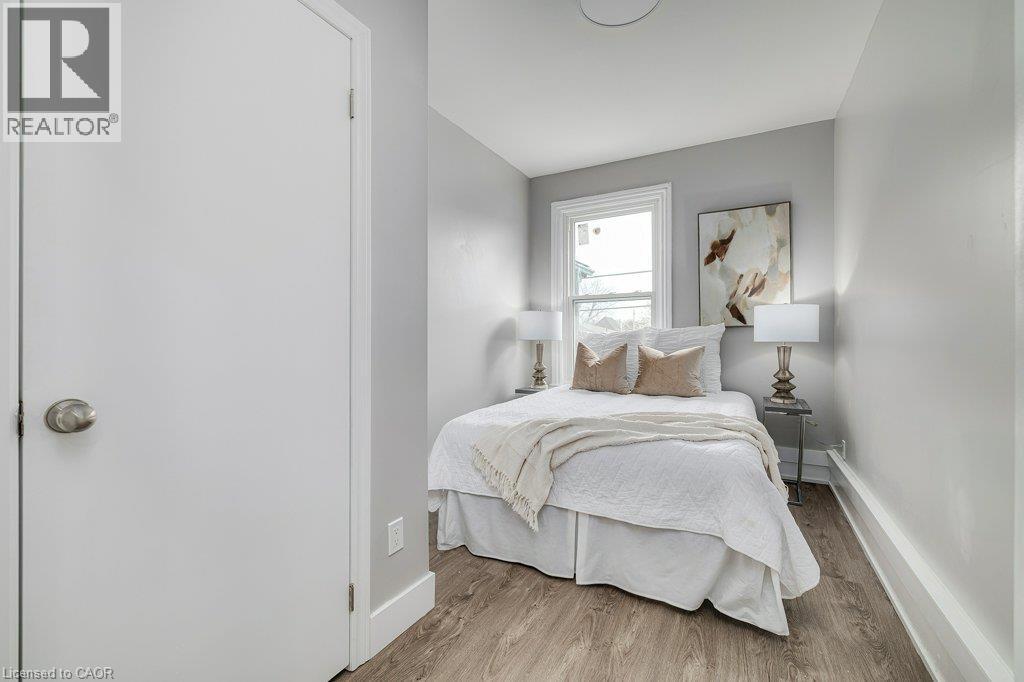Wood-finish flooring with light gray walls, a window with white trim, and a flush-mount ceiling light - 125 Cathcart Street, Hamilton, ON