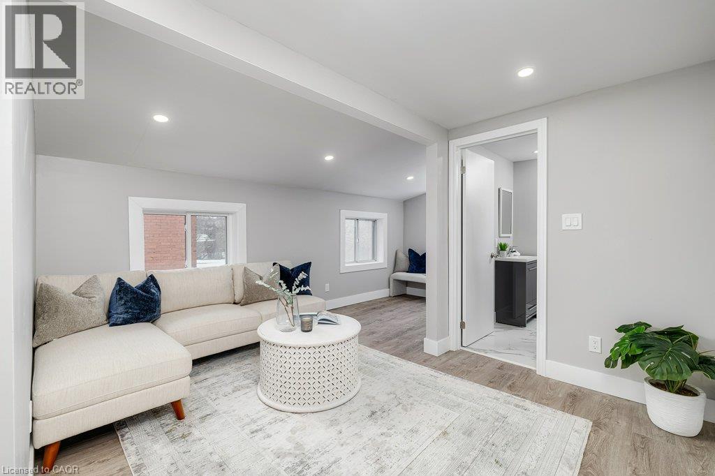 Recessed lighting, wood-finish flooring, light gray wall paint, white trim, and a separate room with a dark vanity - 125 Cathcart Street, Hamilton, ON
