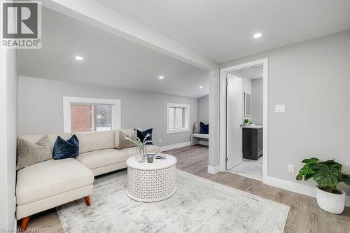 Recessed lighting, wood-finish flooring, light gray wall paint, white trim, and a separate room with a dark vanity - 125 Cathcart Street, Hamilton, ON 