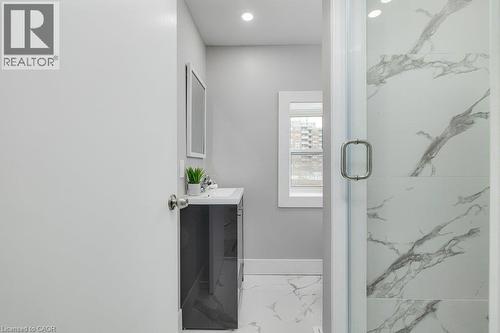 Shower with clear glass enclosure, white and grey veined wall tile, and recessed lighting - 125 Cathcart Street, Hamilton, ON 