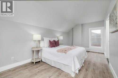 Sloped ceiling architecture, recessed lighting, wood-finish flooring, white trim, and a white framed window - 125 Cathcart Street, Hamilton, ON 