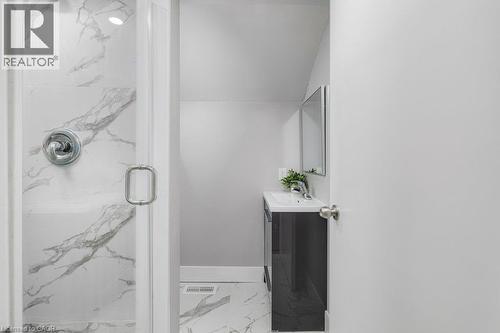 Glass-enclosed shower with chrome fixtures, white and gray veined tile, and recessed lighting - 125 Cathcart Street, Hamilton, ON 