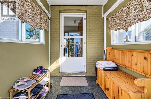 Enclosed entryway featuring painted brick walls, multiple windows, and a glass-paneled entry door - 3 Craigmiller Avenue, Hamilton, ON 