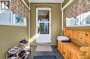 Enclosed entryway featuring painted brick walls, multiple windows, and a glass-paneled entry door - 3 Craigmiller Avenue, Hamilton, ON 