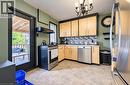 Kitchen featuring light wood-finish cabinetry, stainless steel appliances, mosaic tile backsplash, and direct access to an outdoor deck - 3 Craigmiller Avenue, Hamilton, ON 