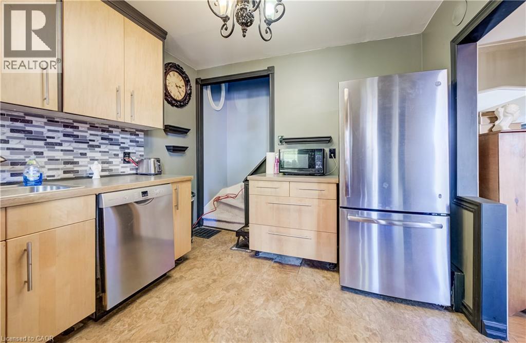 Kitchen featuring wood-finish cabinetry, stainless steel dishwasher, and stainless steel refrigerator - 3 Craigmiller Avenue, Hamilton, ON