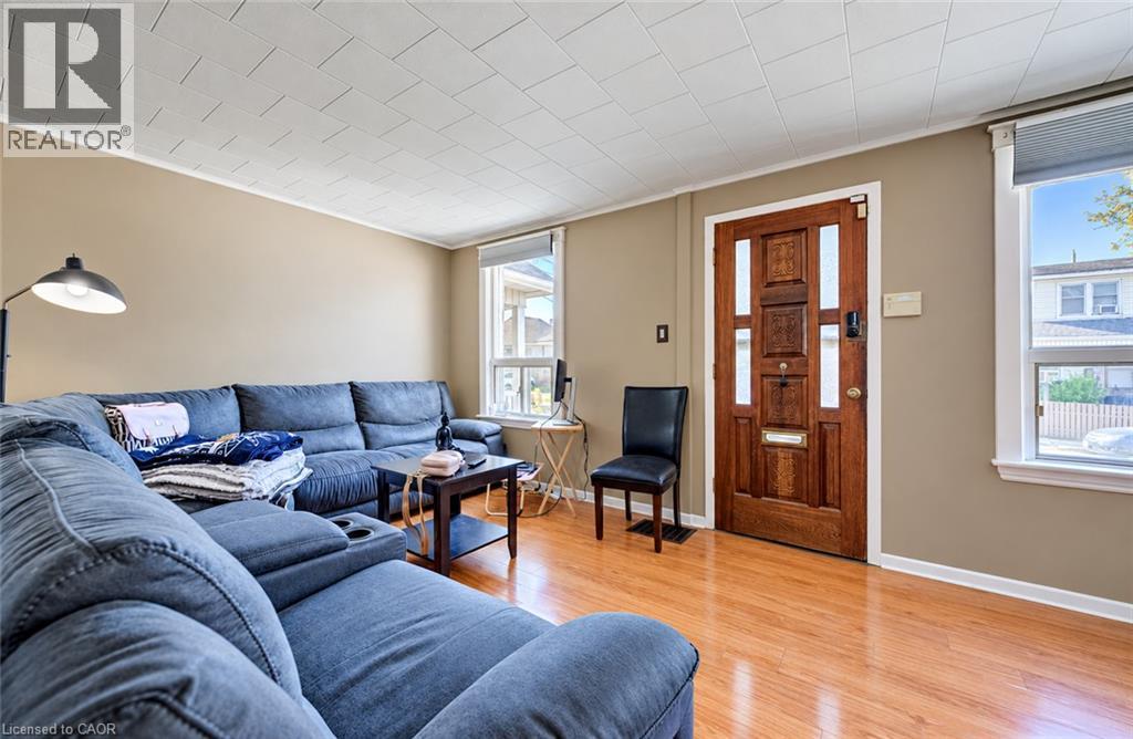 Hardwood-finish flooring, paneled entry door with sidelights, neutral wall tones, and white trim - 3 Craigmiller Avenue, Hamilton, ON