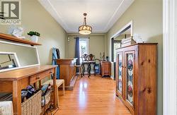 Wood-finish flooring throughout, recessed ceiling detail, and a decorative ceiling light fixture -
