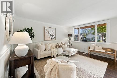 Hardwood flooring, crown molding, white wall paneling, and a large multi-pane window - 284 East 21St Street, Hamilton, ON 
