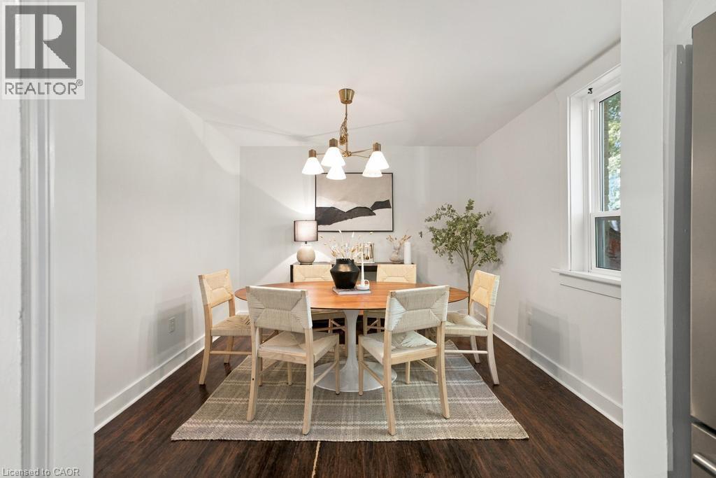 Recessed dining area with a brass chandelier, wood-finish flooring, and white walls - 284 East 21St Street, Hamilton, ON