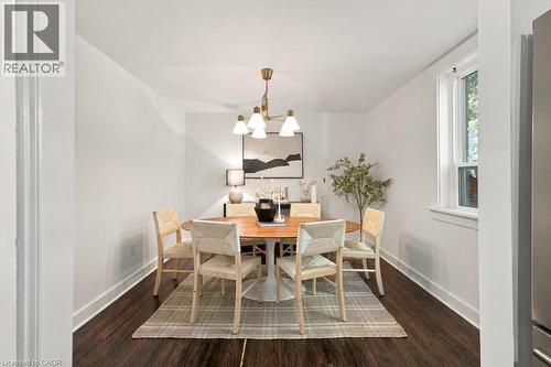 Recessed dining area with a brass chandelier, wood-finish flooring, and white walls - 284 East 21St Street, Hamilton, ON 