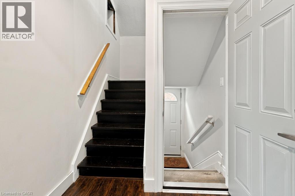 Dark-stained wood stairs with a natural wood handrail - 284 East 21St Street, Hamilton, ON