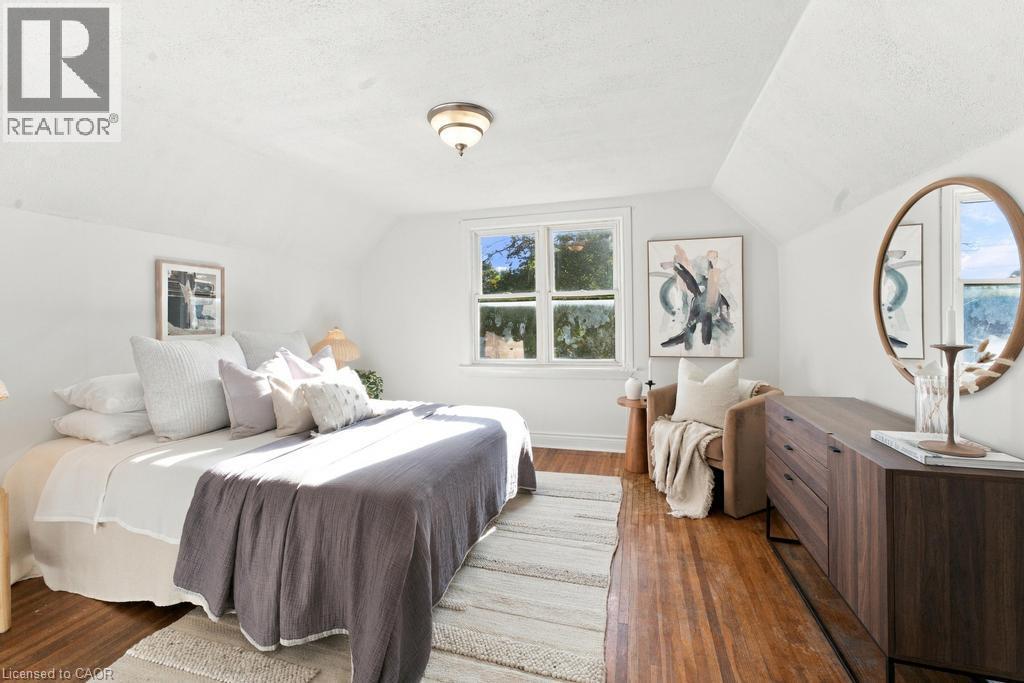 Hardwood flooring, multi-pane window, white walls, built-in ceiling light fixture, sloped ceiling - 284 East 21St Street, Hamilton, ON