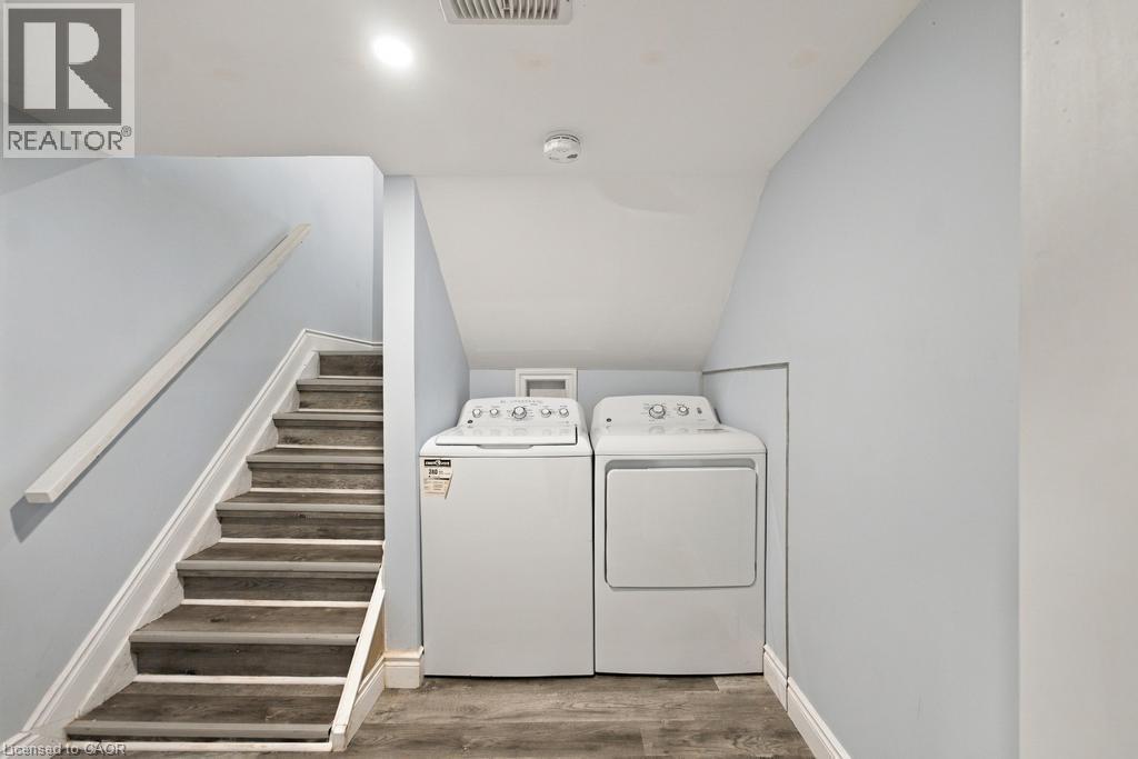 Staircase with wood-finish treads and white risers, accompanied by a white handrail - 284 East 21St Street, Hamilton, ON