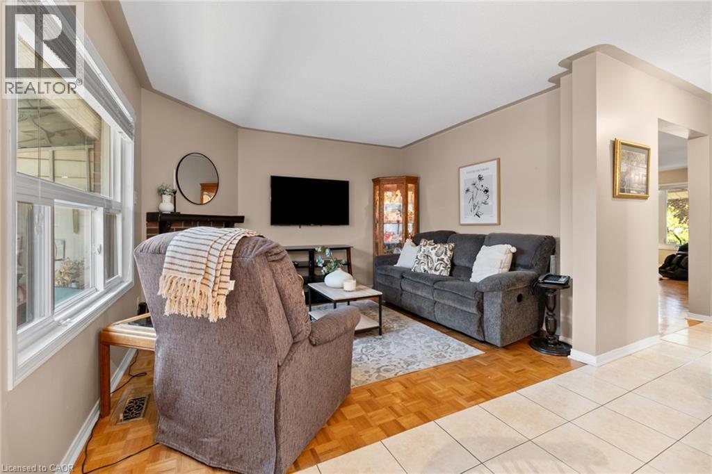 Bay window with white trim, brick-clad fireplace, wood-finish flooring, recessed wall niche, and tile flooring - 1263 Bantham Street, Mississauga, ON