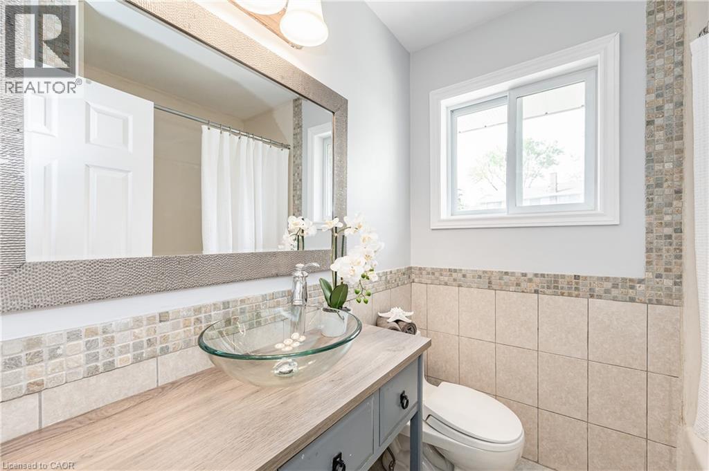 Modern vanity featuring a glass vessel sink and wood-finish countertop - 388 Appleby Line, Burlington, ON