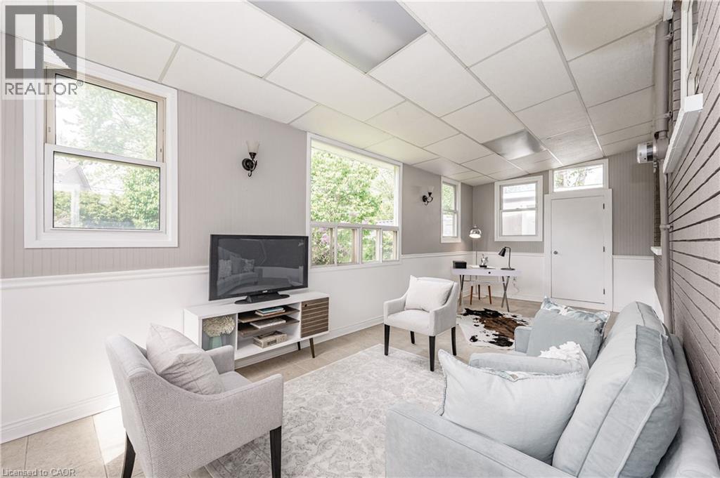 Recessed panel ceiling, wood-finish flooring, multiple windows, decorative wall sconces, and beadboard wainscoting - 388 Appleby Line, Burlington, ON