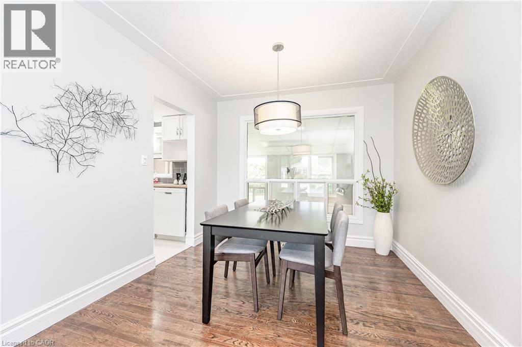 Hardwood flooring, elegant pendant light fixture, large window, white trim, and a clear passageway - 388 Appleby Line, Burlington, ON
