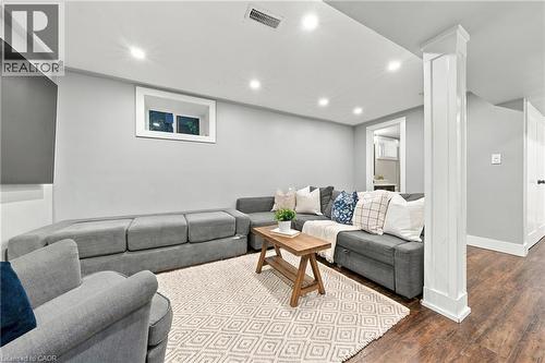 Recessed lighting illuminates the living space, featuring wood-finish flooring and a white trimmed window - 1231 Dunsmure Road, Hamilton, ON 