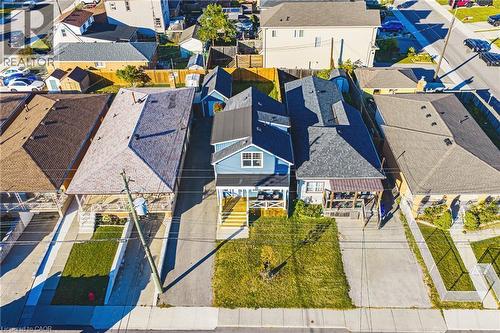 Blue exterior siding with white trim, a covered porch, a front lawn, and a driveway - 1231 Dunsmure Road, Hamilton, ON 