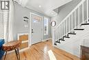 Light wood-finish flooring, white painted staircase with dark treads, white front entry door with glass panels, recessed lighting, and a white window frame - 1231 Dunsmure Road, Hamilton, ON 