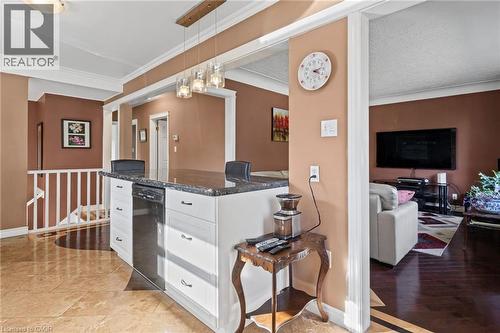 Kitchen island with dark countertop, integrated dishwasher, and white cabinetry - 366 East 17Th Street, Hamilton, ON 
