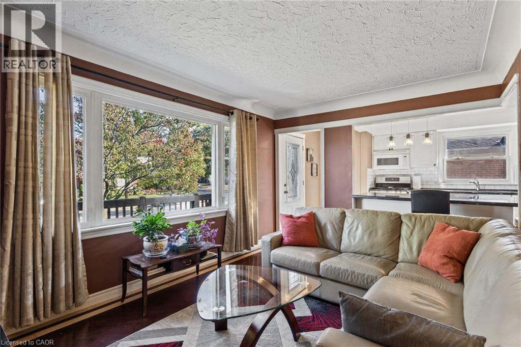 Expansive bay window, wood-finish flooring, white crown molding, recessed lighting, and kitchen with white subway tile backsplash - 366 East 17Th Street, Hamilton, ON