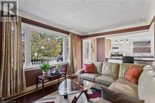 Expansive bay window, wood-finish flooring, white crown molding, recessed lighting, and kitchen with white subway tile backsplash - 366 East 17Th Street, Hamilton, ON 