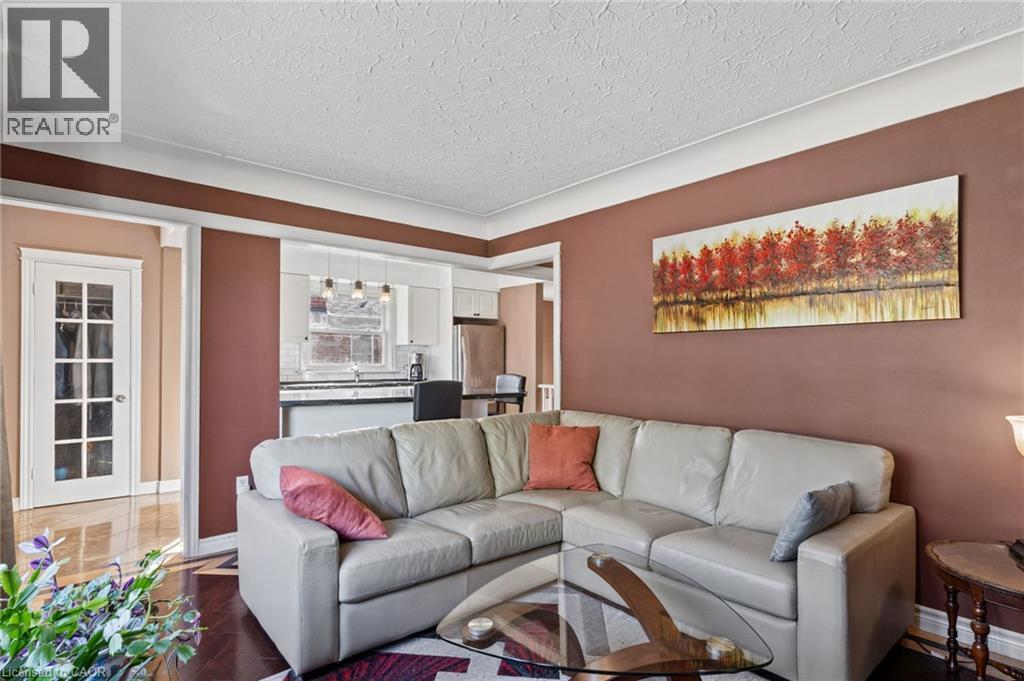 Wood-finish flooring, white crown molding, and a white French door with glass panels - 366 East 17Th Street, Hamilton, ON