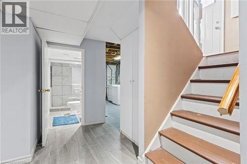 Tiled flooring, built-in storage cabinetry, three-quarter bathroom with tiled shower, wood-finish stairs with white risers - 366 East 17Th Street, Hamilton, ON 