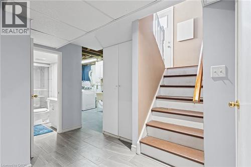 Wood-finish flooring, white built-in cabinetry, and a staircase with a wood handrail - 366 East 17Th Street, Hamilton, ON 