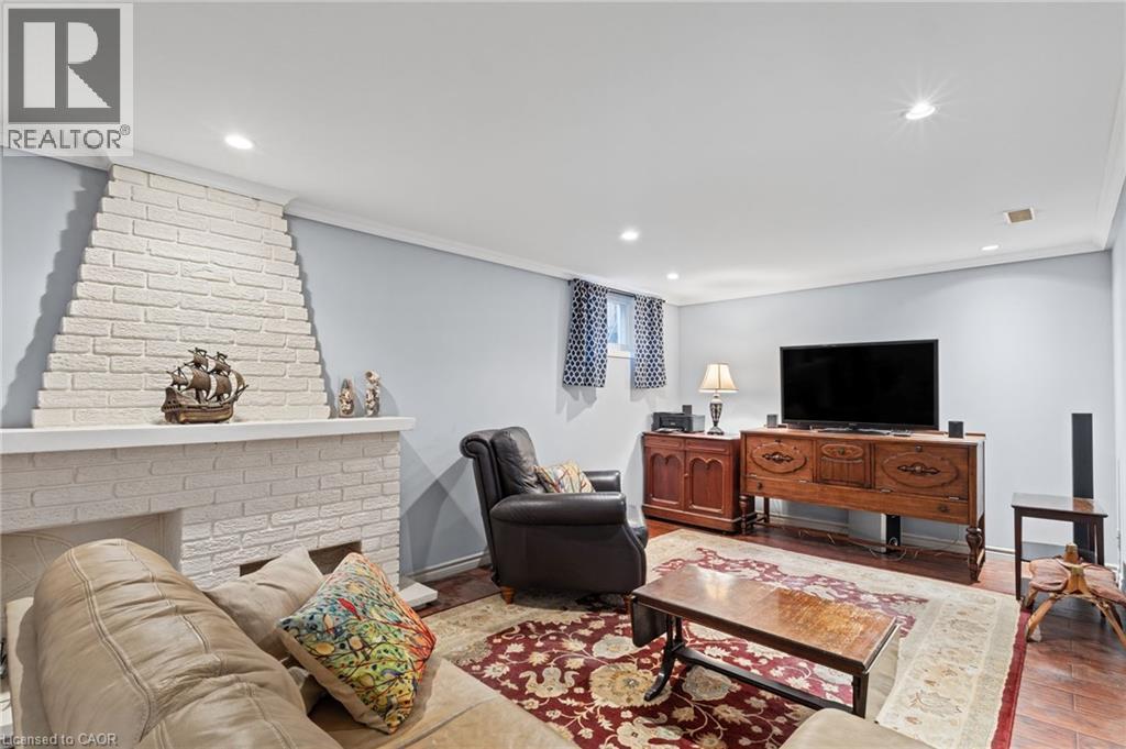 White painted brick fireplace, recessed lighting, crown molding, and a window with patterned curtains - 366 East 17Th Street, Hamilton, ON
