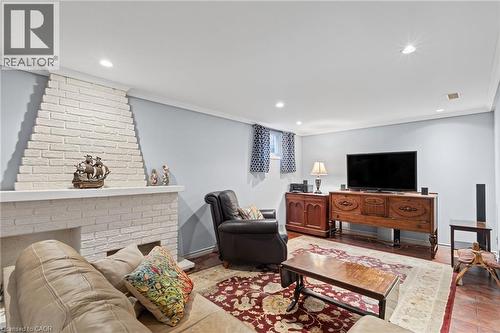 White painted brick fireplace, recessed lighting, crown molding, and a window with patterned curtains - 366 East 17Th Street, Hamilton, ON 
