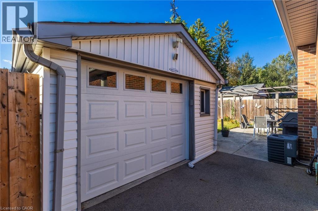Attached garage with an overhead door featuring transom windows - 366 East 17Th Street, Hamilton, ON