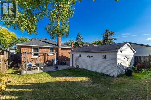 Expansive grassy yard with a concrete patio, brick exterior, and detached garage - 366 East 17Th Street, Hamilton, ON 