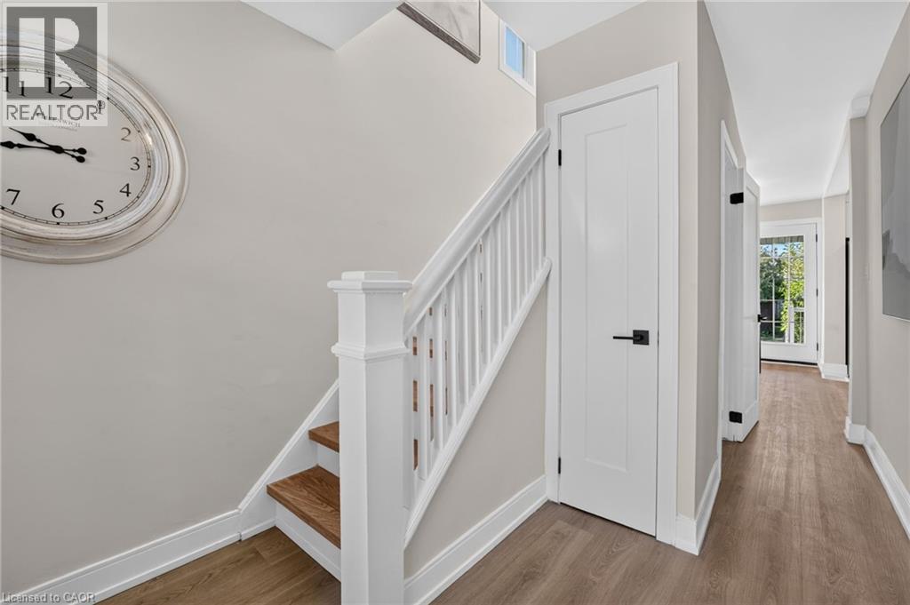 Warm wood-finish flooring, white trim, and light gray wall paint - 215 Paling Avenue, Hamilton, ON