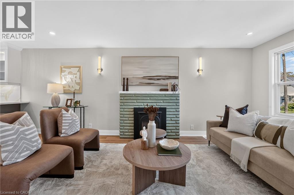 Recessed lighting, wood-finish flooring, a decorative fireplace with a tiled surround, and wall sconces - 215 Paling Avenue, Hamilton, ON