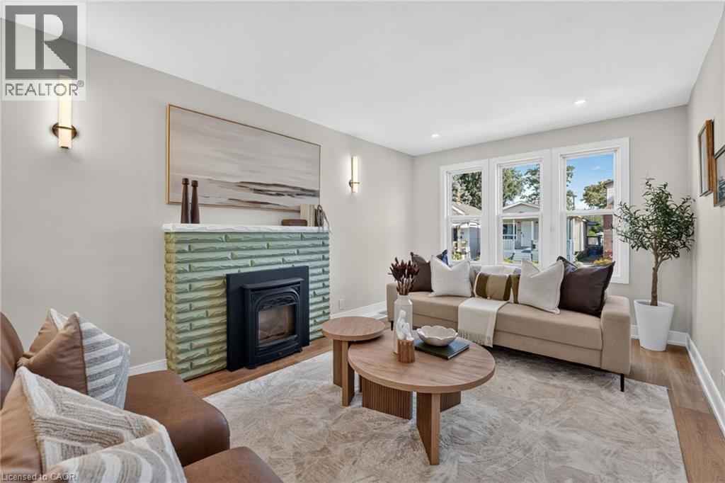 Fireplace featuring a fluted green surround and white mantel - 215 Paling Avenue, Hamilton, ON