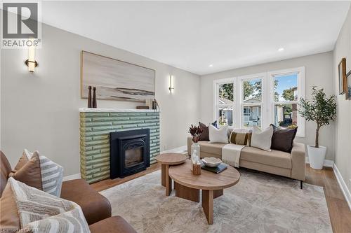 Fireplace featuring a fluted green surround and white mantel - 215 Paling Avenue, Hamilton, ON 