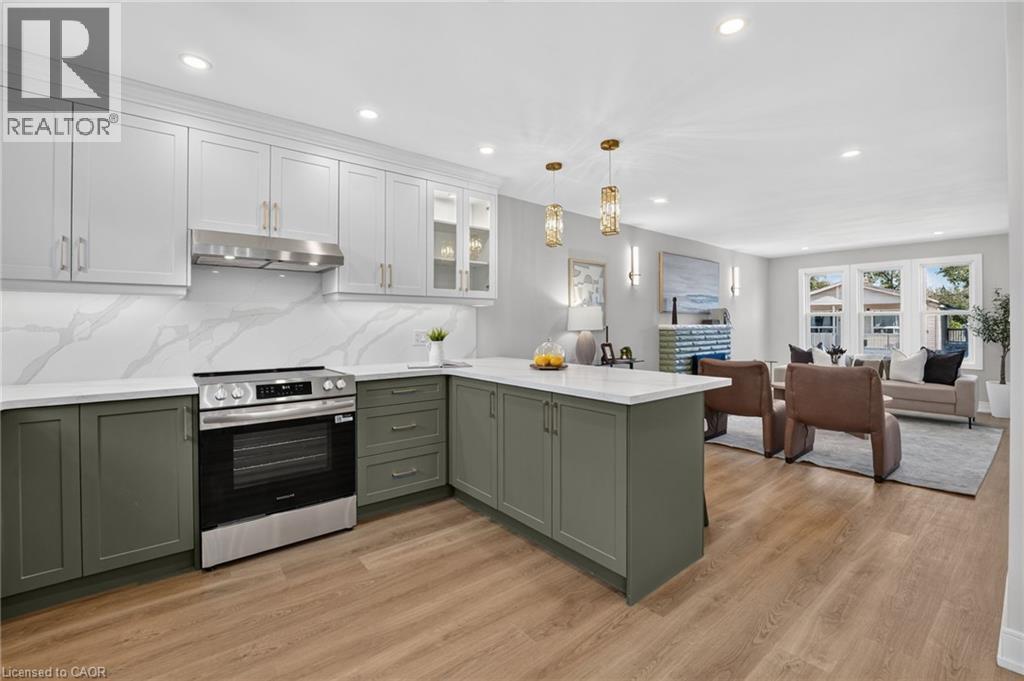 Well-appointed kitchen featuring two-tone cabinetry, stainless steel range, and stone countertops - 215 Paling Avenue, Hamilton, ON