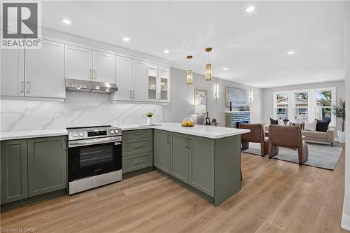 Well-appointed kitchen featuring two-tone cabinetry, stainless steel range, and stone countertops - 215 Paling Avenue, Hamilton, ON 