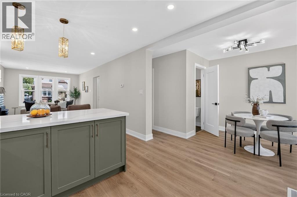 Kitchen island with quartz countertop and green cabinetry - 215 Paling Avenue, Hamilton, ON