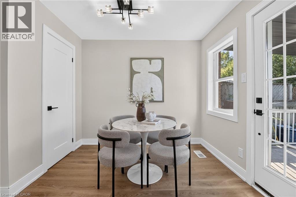 Wood-finish flooring, white trim, recessed window, and white paneled interior door with matte black hardware - 215 Paling Avenue, Hamilton, ON