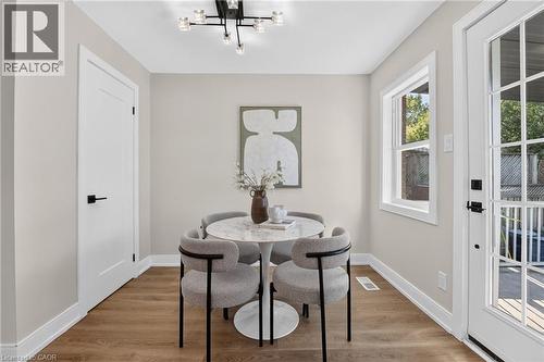 Wood-finish flooring, white trim, recessed window, and white paneled interior door with matte black hardware - 215 Paling Avenue, Hamilton, ON 