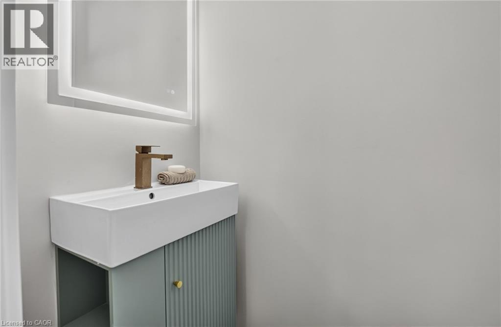 Modern vanity with an integrated rectangular basin, featuring a bronze-finish faucet - 215 Paling Avenue, Hamilton, ON