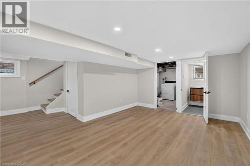 Spacious finished basement featuring wood-finish flooring, recessed lighting, and a dedicated laundry area - 215 Paling Avenue, Hamilton, ON 