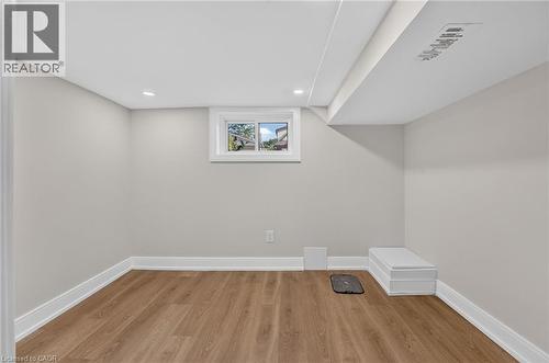 Recessed ceiling lighting, wood-finish flooring, and a white-framed window - 215 Paling Avenue, Hamilton, ON 