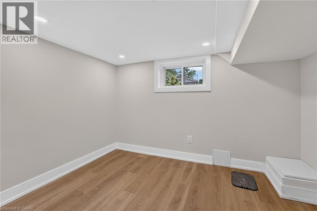 Recessed lighting, light wood-finish flooring, neutral wall color, white trim, and a window - 215 Paling Avenue, Hamilton, ON